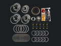 A complete bearing and seal kit laid out on a white background, including multiple tapered roller bearings, flat and rubber seals, washers, small hardware pieces, and a tube of grease with a brush.